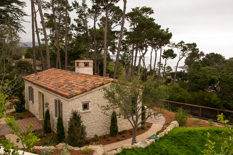 Ispirazione per la facciata di una casa beige mediterranea a un piano con rivestimento in pietra e tetto a capanna