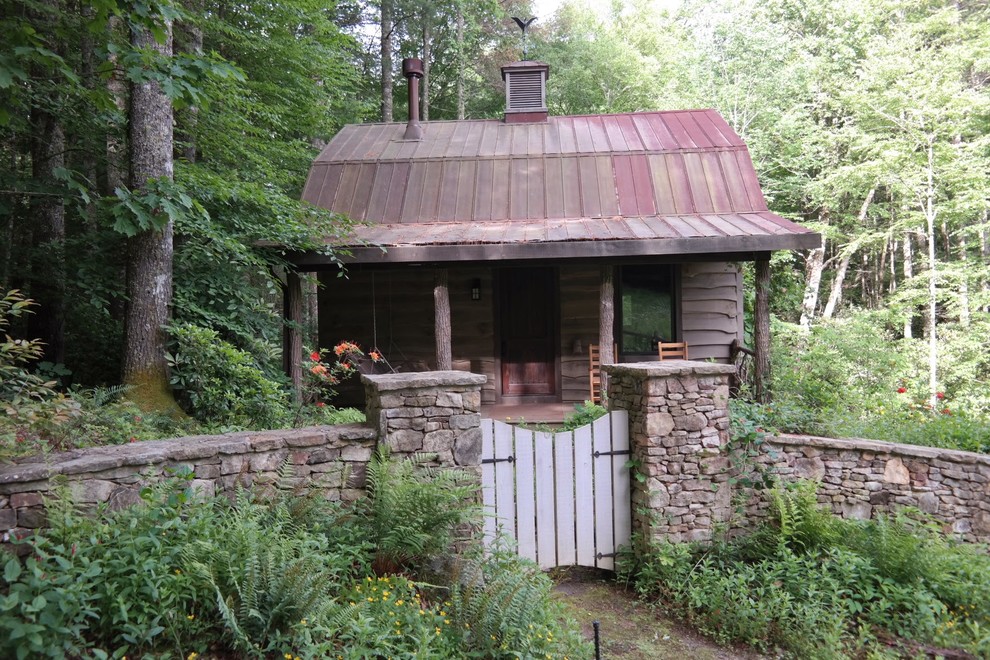 Esempio della facciata di una casa beige rustica a un piano di medie dimensioni con rivestimento in legno e tetto a capanna