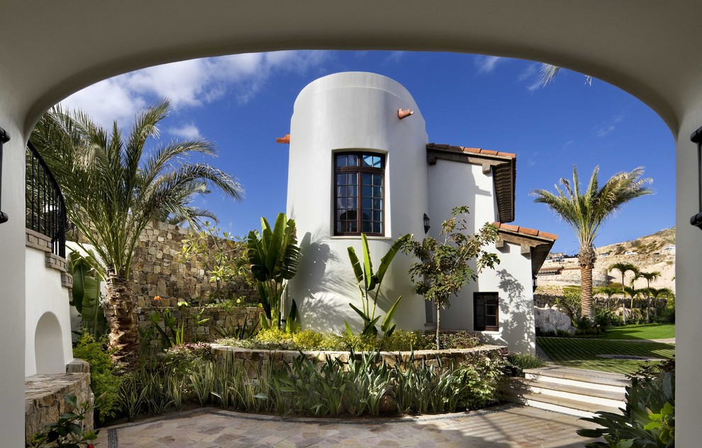 Ispirazione per la facciata di una casa bianca tropicale a due piani di medie dimensioni con rivestimento in stucco e tetto piano