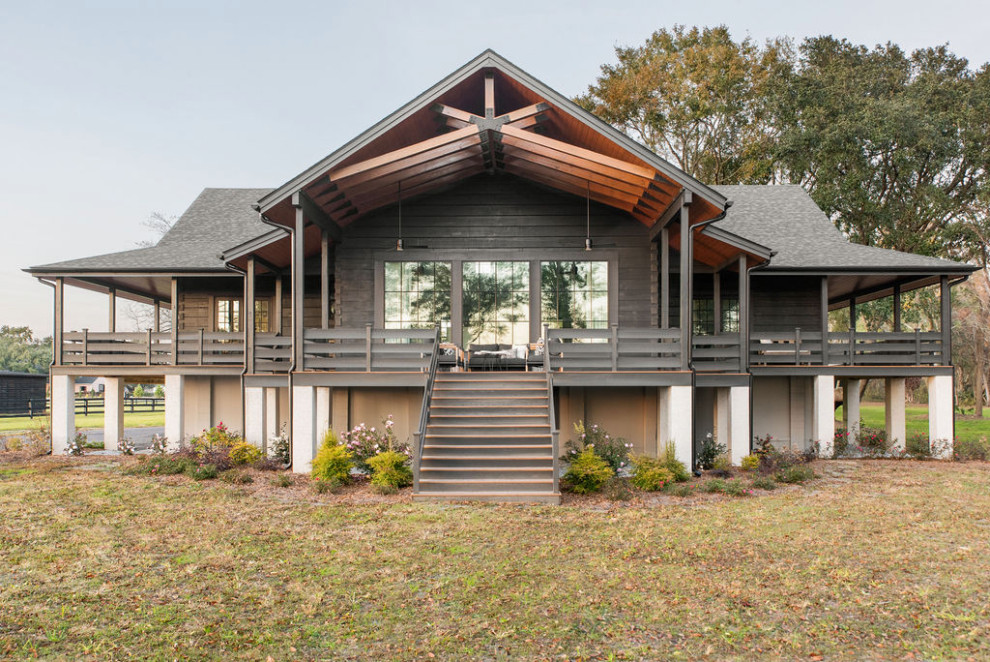 Ejemplo de fachada de casa negra de estilo de casa de campo de dos plantas con revestimiento de madera, tejado a dos aguas y tejado de teja de madera