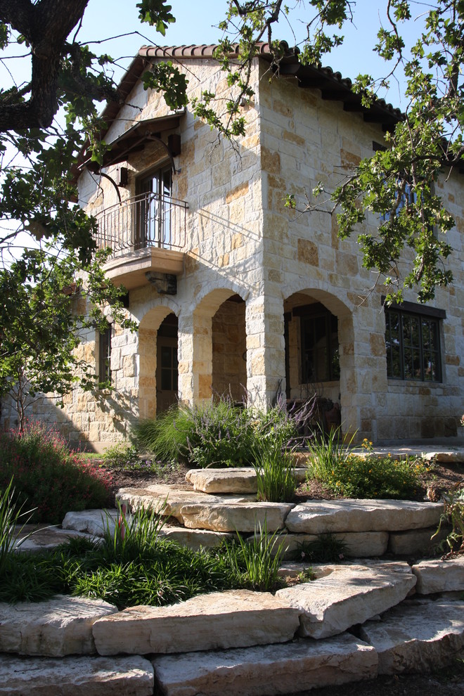 Example of a tuscan stone exterior home design in Austin