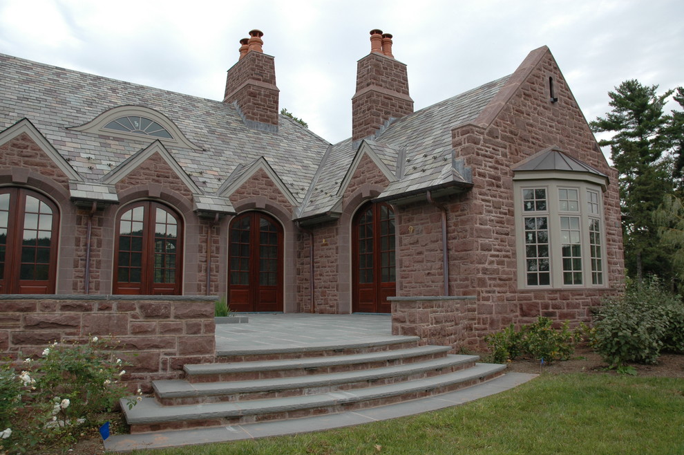 This is an example of an expansive and brown classic two floor brick detached house in Philadelphia with a half-hip roof and a shingle roof.