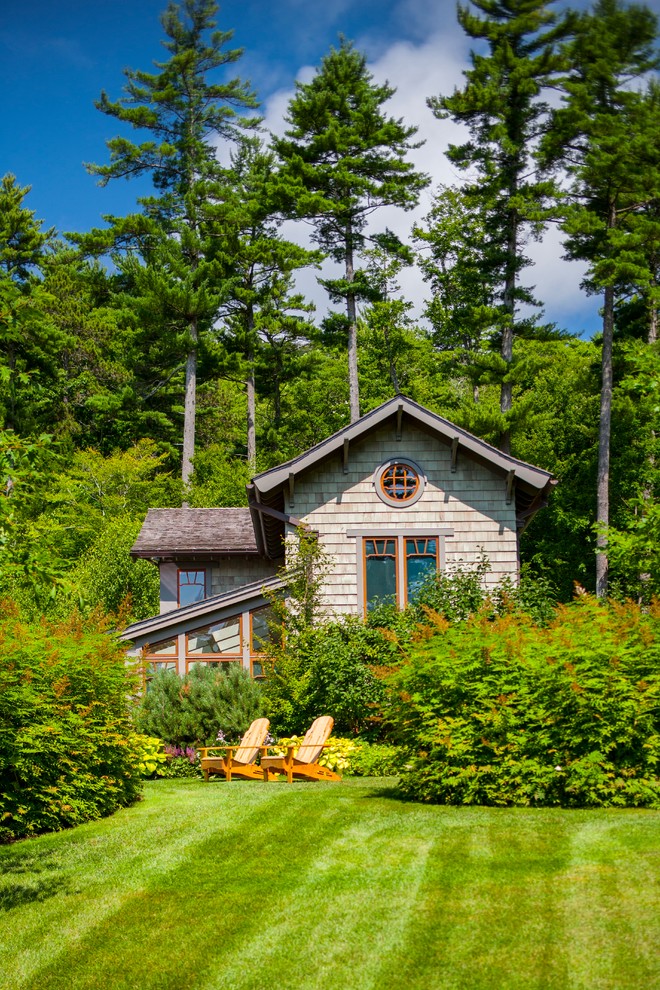 Foto della villa piccola verde american style a due piani con rivestimento in legno, tetto a capanna e copertura a scandole