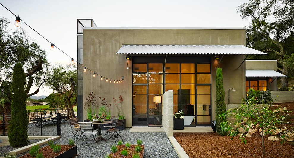 Idée de décoration pour une petite façade de maison beige design en stuc de plain-pied avec un toit plat.