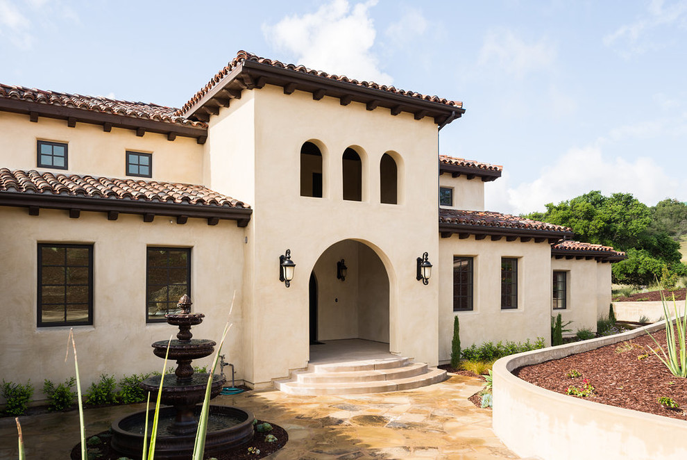 Mittelgroßes, Zweistöckiges Mediterranes Einfamilienhaus mit Putzfassade, gelber Fassadenfarbe, Satteldach und Ziegeldach in San Luis Obispo