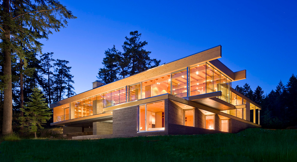 Ejemplo de fachada de casa marrón minimalista de dos plantas con revestimiento de vidrio y tejado plano