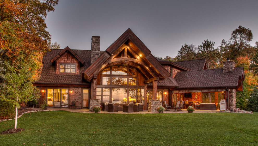 Large mountain style brown two-story stone exterior home photo in Minneapolis with a shingle roof