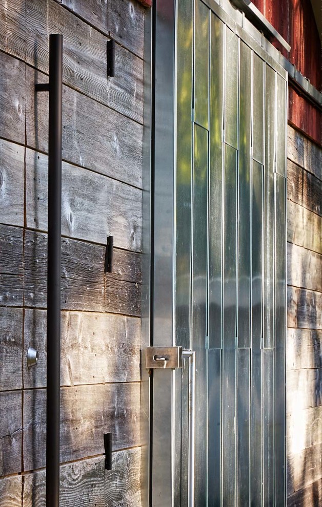 Immagine della facciata di una casa industriale a un piano di medie dimensioni con rivestimenti misti e copertura in metallo o lamiera