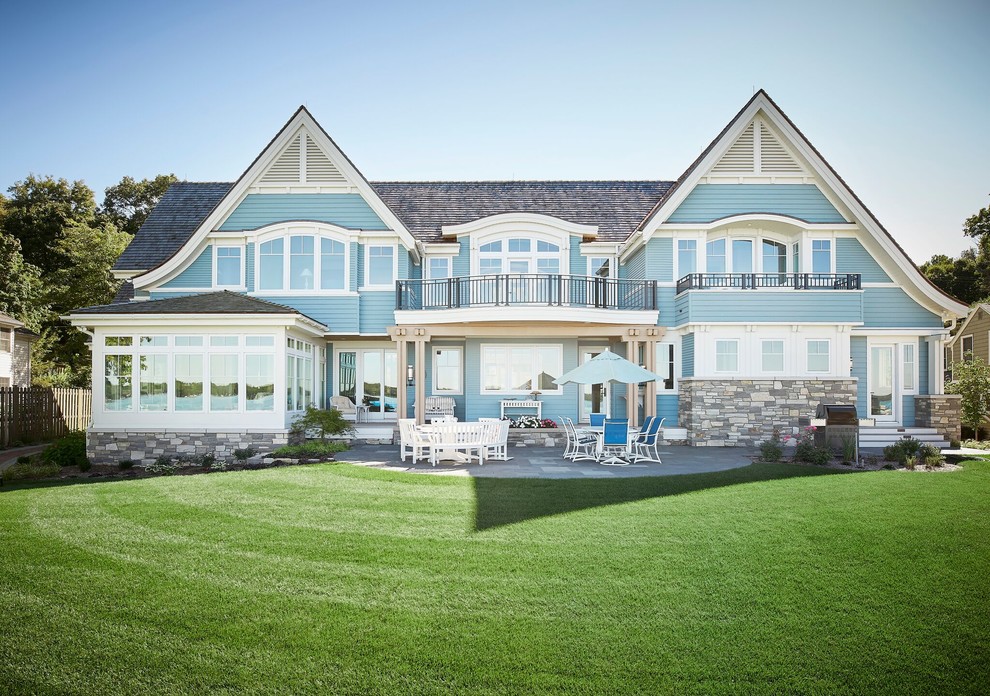 Immagine della villa ampia blu stile marinaro a due piani con rivestimento in legno, tetto a capanna e copertura a scandole