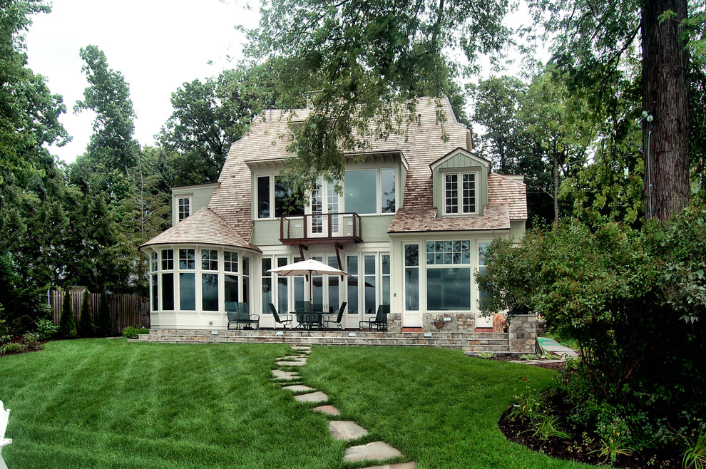 Пример оригинального дизайна: большой, двухэтажный, зеленый частный загородный дом в классическом стиле с облицовкой из камня и крышей из гибкой черепицы