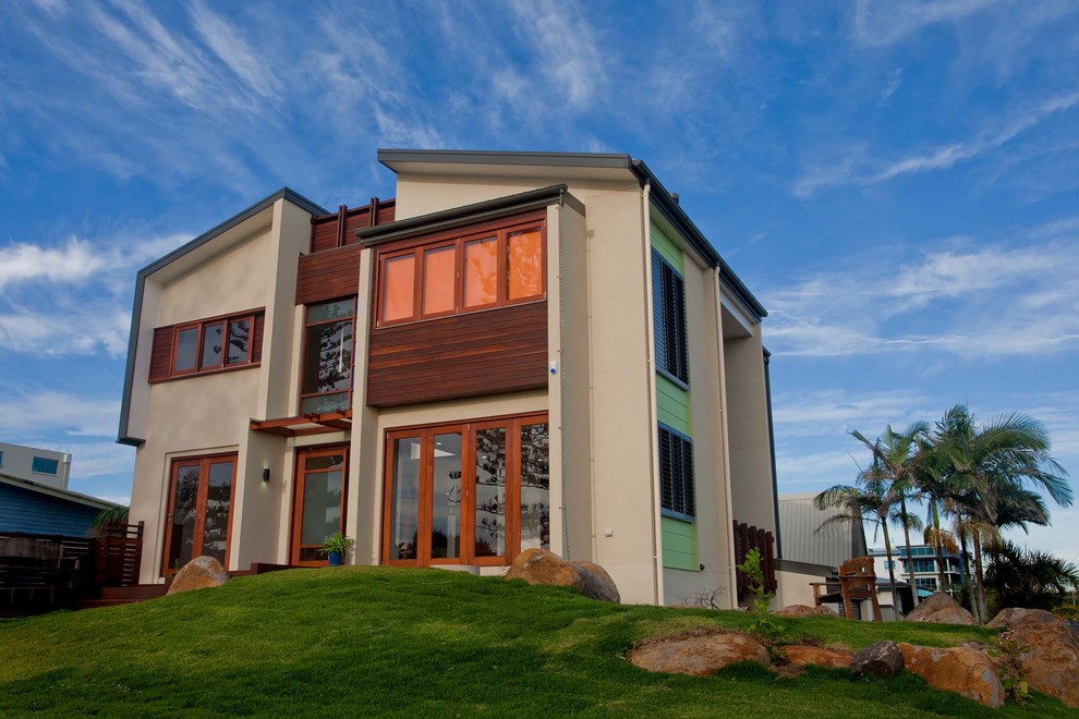 Réalisation d'une façade de maison beige design en bois de taille moyenne et à deux étages et plus avec un toit en appentis.