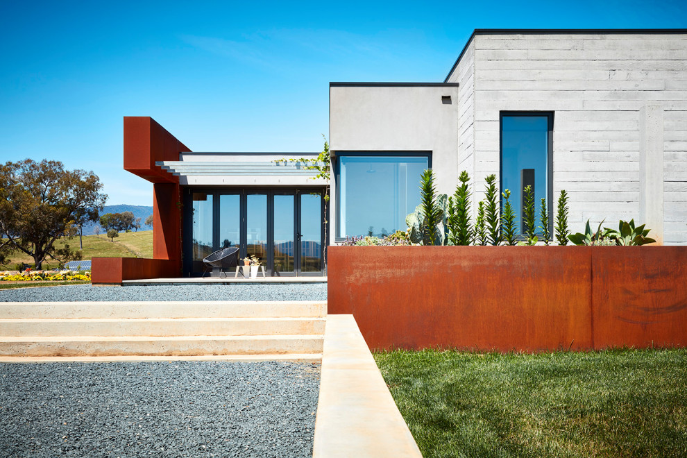 Diseño de fachada de casa roja contemporánea grande de una planta con revestimiento de metal, tejado plano y tejado de metal
