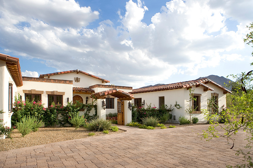 Example of a large tuscan white one-story stucco gable roof design in Phoenix