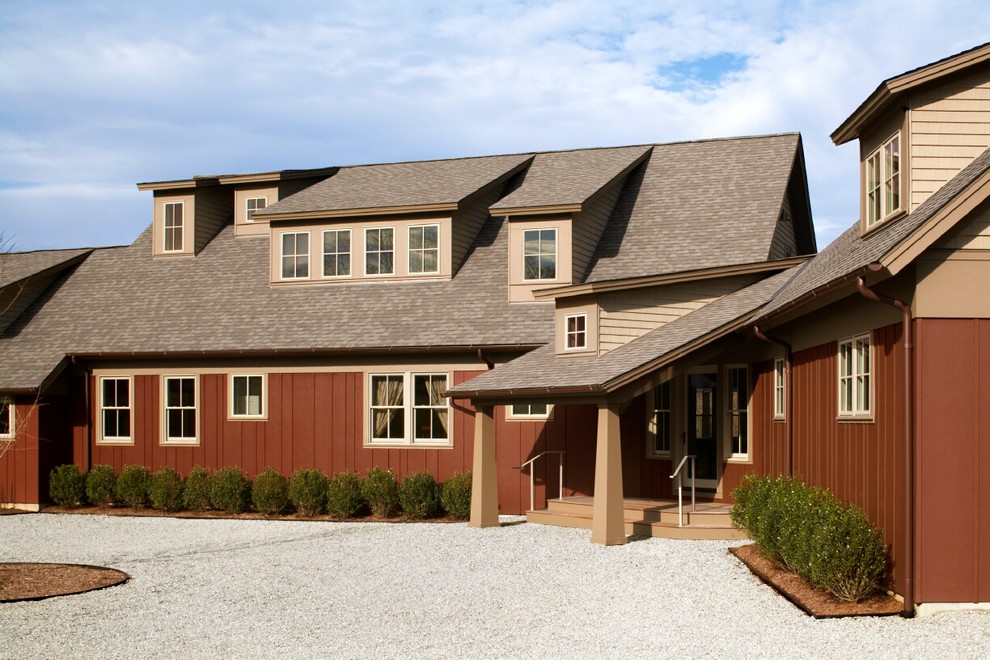 Diseño de fachada de casa roja contemporánea de tamaño medio de dos plantas con revestimiento de aglomerado de cemento, tejado a dos aguas y tejado de teja de madera