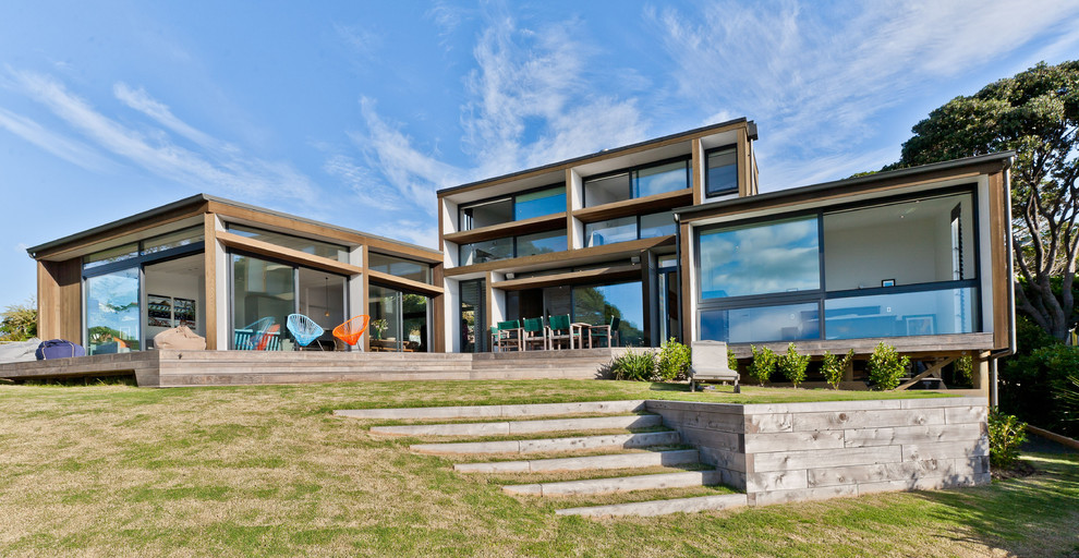 Contemporary split-level glass house exterior in Hamilton with a flat roof.