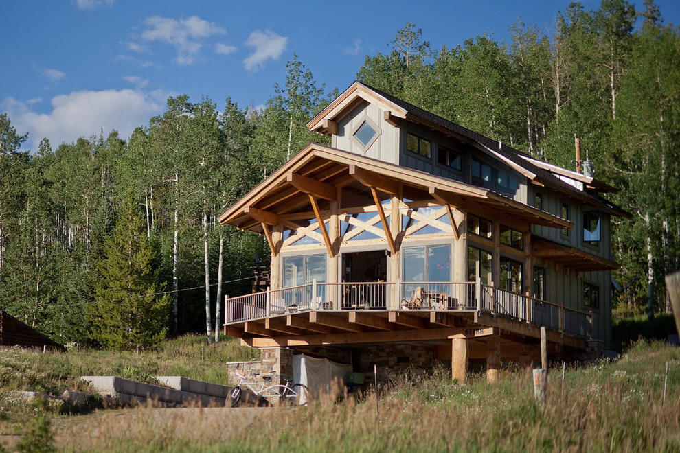 Inspiration pour une façade de maison grise chalet en bois à un étage et de taille moyenne avec un toit à deux pans et un toit en shingle.