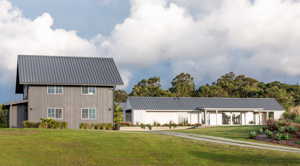 Exemple d'une petite façade de maison grise nature en bois à un étage avec un toit à deux pans et un toit en métal.
