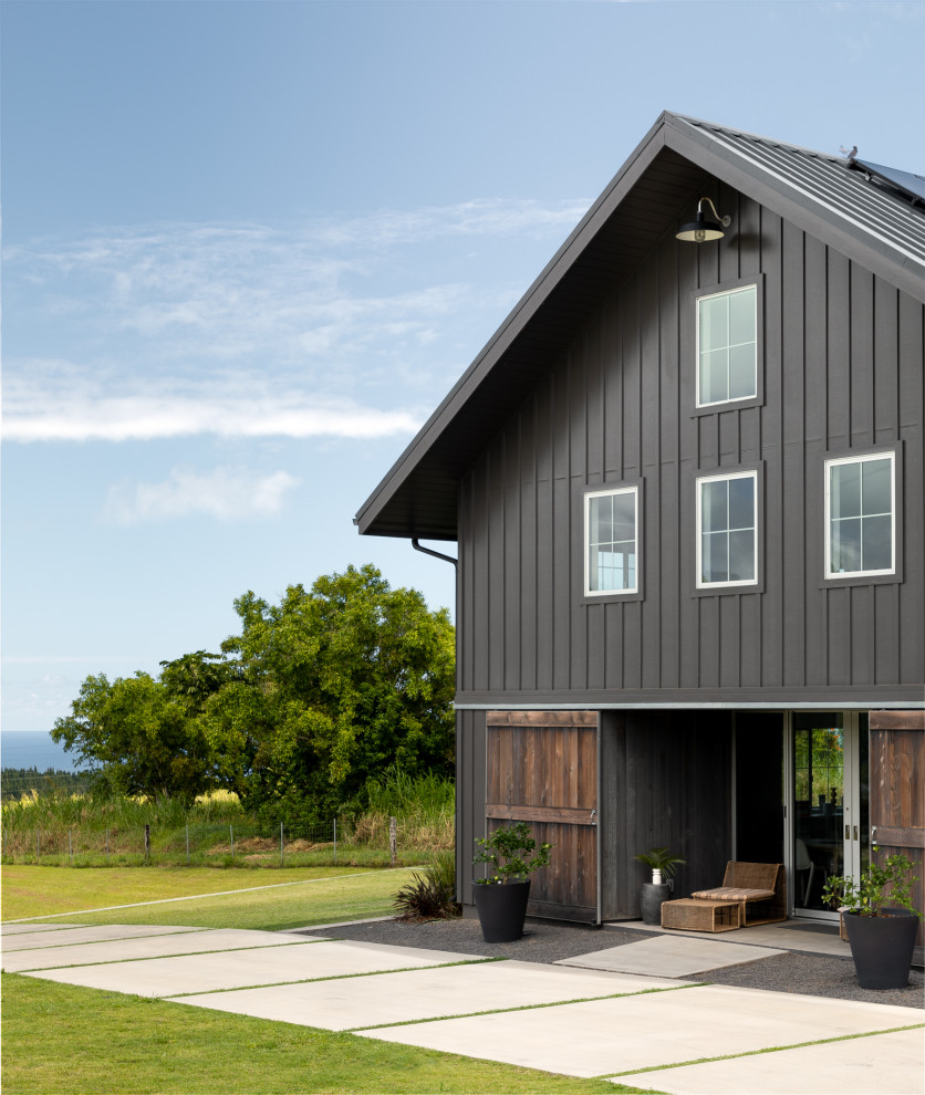 Cette photo montre une petite façade de maison grise nature en bois à un étage avec un toit à deux pans et un toit en métal.