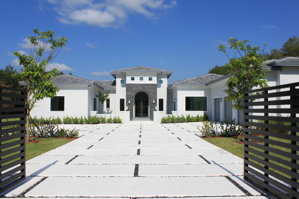 Large and white traditional bungalow detached house in Miami with vinyl cladding, a hip roof and a shingle roof.