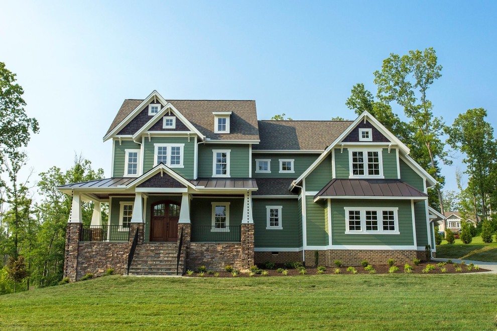 Cette photo montre une grande façade de maison verte chic à un étage avec un revêtement mixte, un toit à deux pans et un toit mixte.