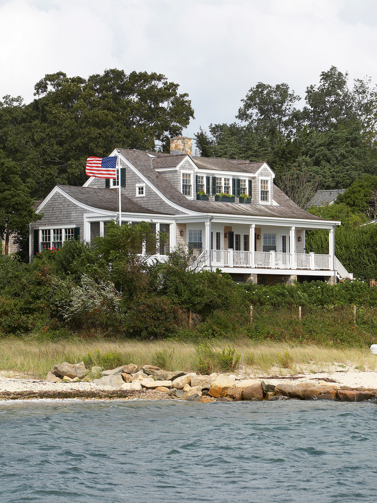 Exemple d'une façade de maison grise bord de mer en bois de taille moyenne et à un étage avec un toit à deux pans.