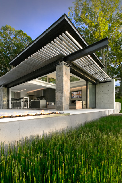 Photo of a large and gey contemporary bungalow concrete house exterior in New York with a flat roof.