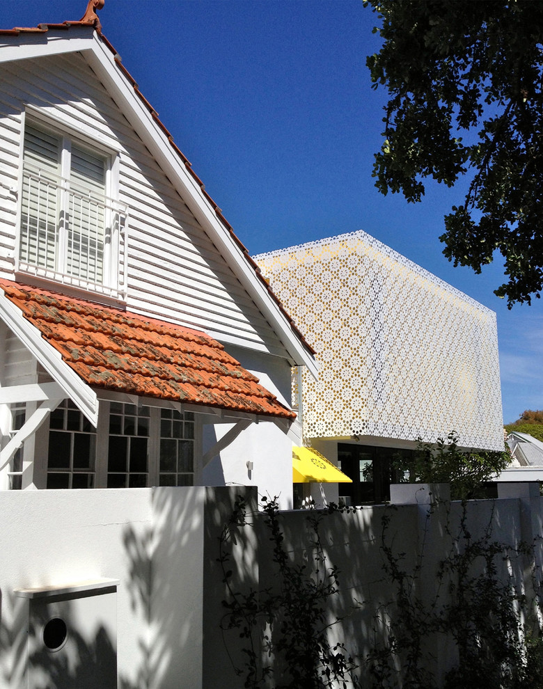 Example of a large trendy yellow two-story metal flat roof design in Perth