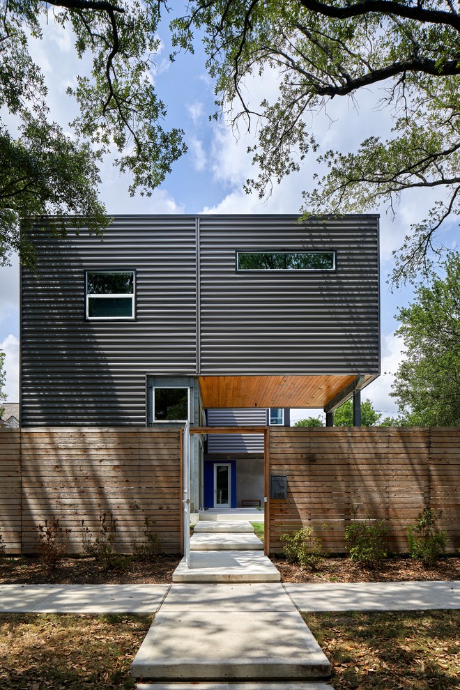 Idée de décoration pour une façade de maison métallique et grise minimaliste de taille moyenne et à un étage avec un toit plat.