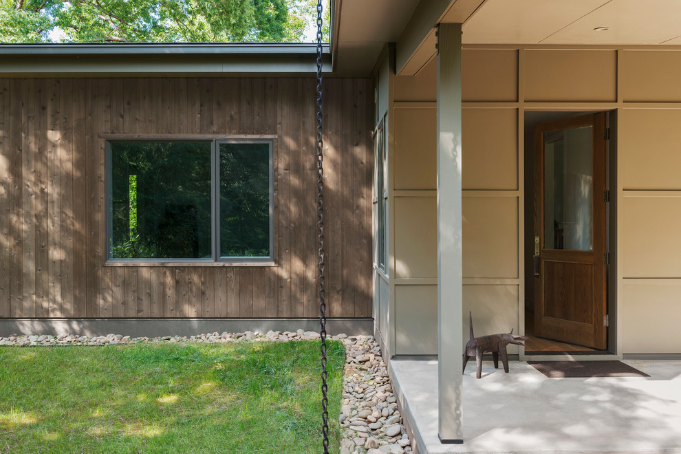 Стильный дизайн: одноэтажный, деревянный, коричневый частный загородный дом среднего размера в стиле модернизм с односкатной крышей и металлической крышей - последний тренд