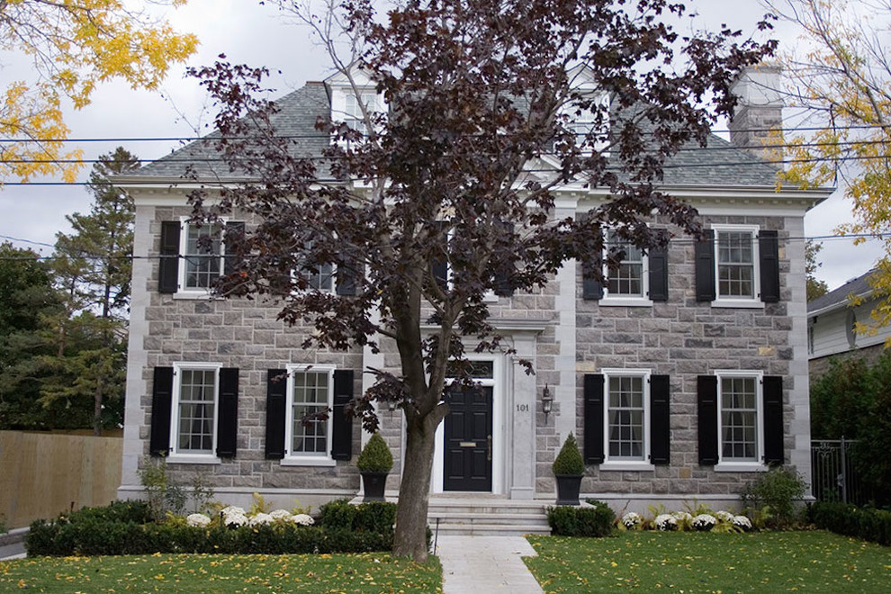 Example of a mid-sized classic three-story stone exterior home design in Montreal with a hip roof