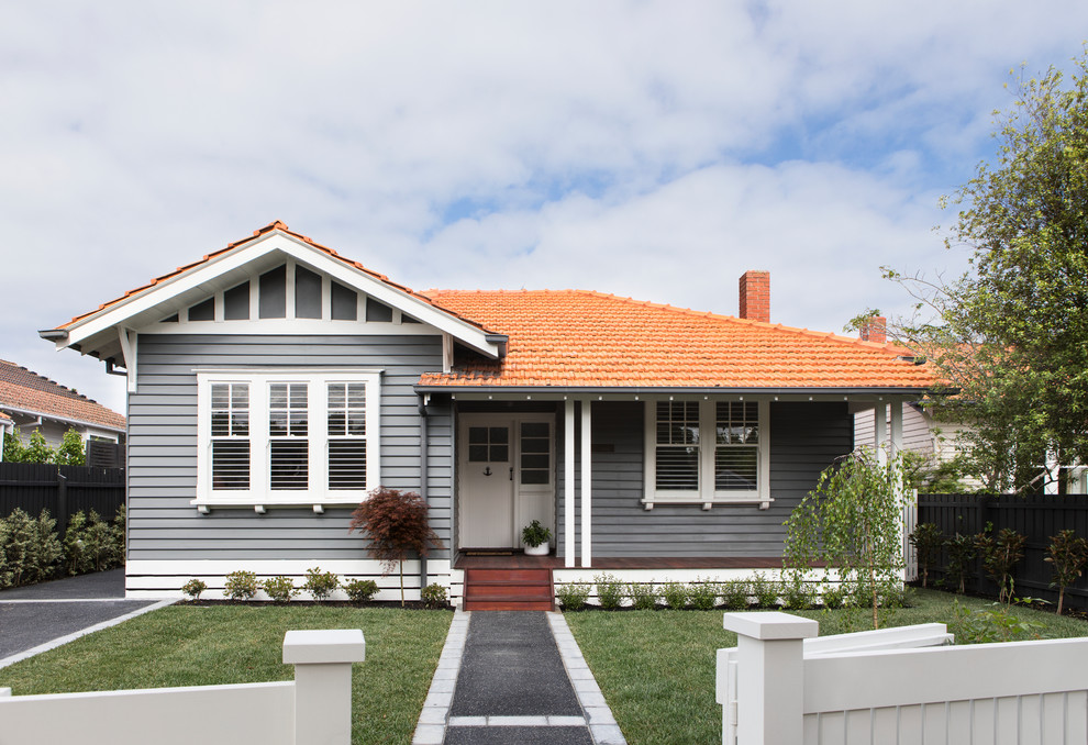 Diseño de fachada de casa gris tradicional de dos plantas con revestimiento de madera, tejado a dos aguas y tejado de teja de barro