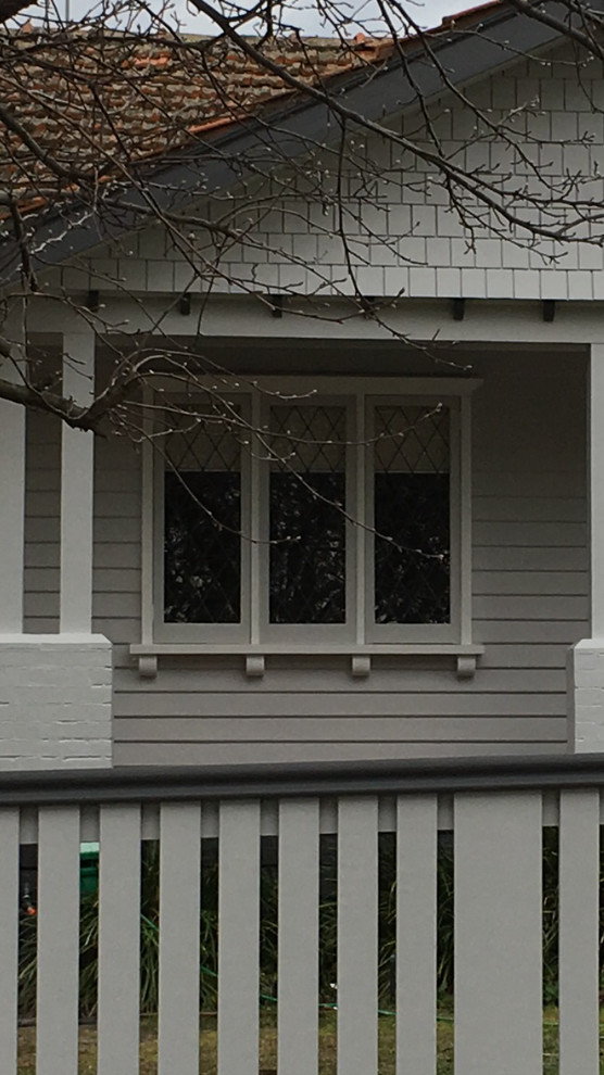 Cette photo montre une façade de maison grise chic en bois.
