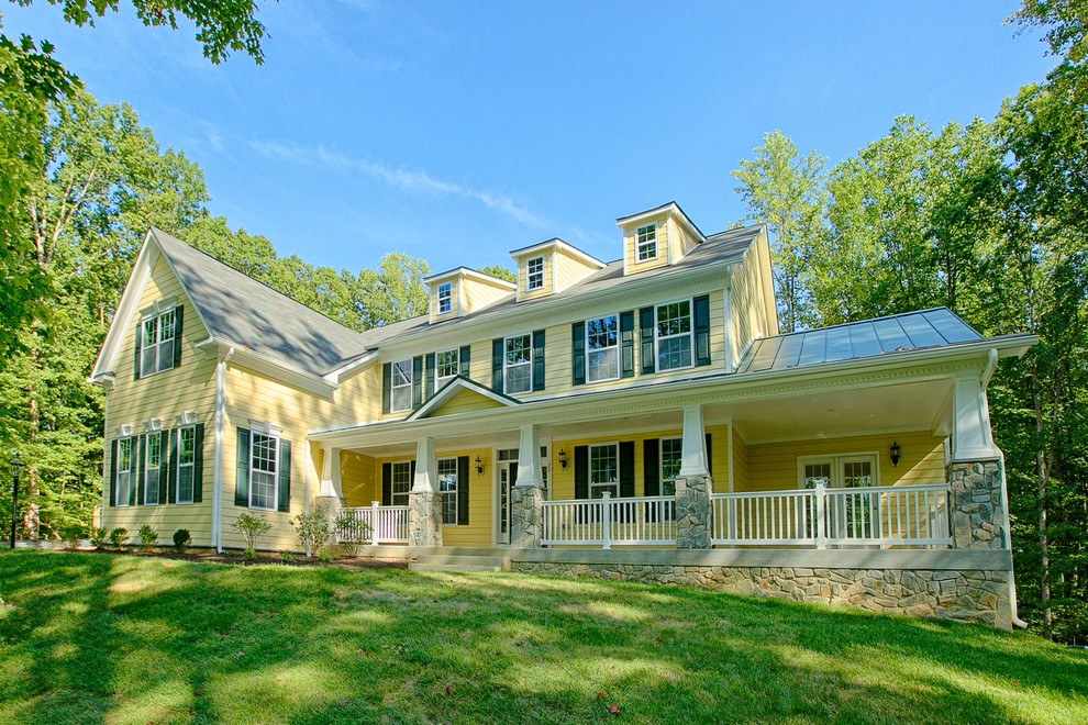ワシントンD.C.にある高級なトラディショナルスタイルのおしゃれな家の外観 (黄色い外壁、ビニールサイディング、混合材屋根) の写真