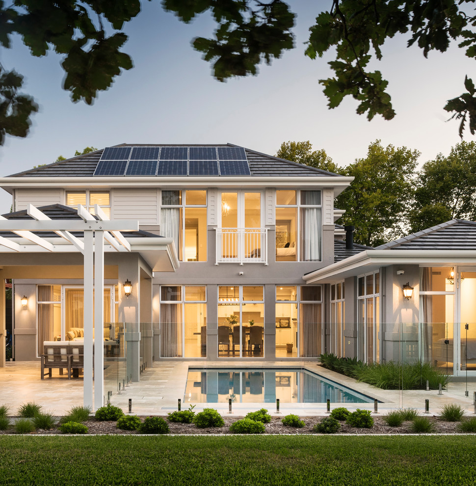 Идея дизайна: двухэтажный, серый частный загородный дом в морском стиле с комбинированной облицовкой и вальмовой крышей