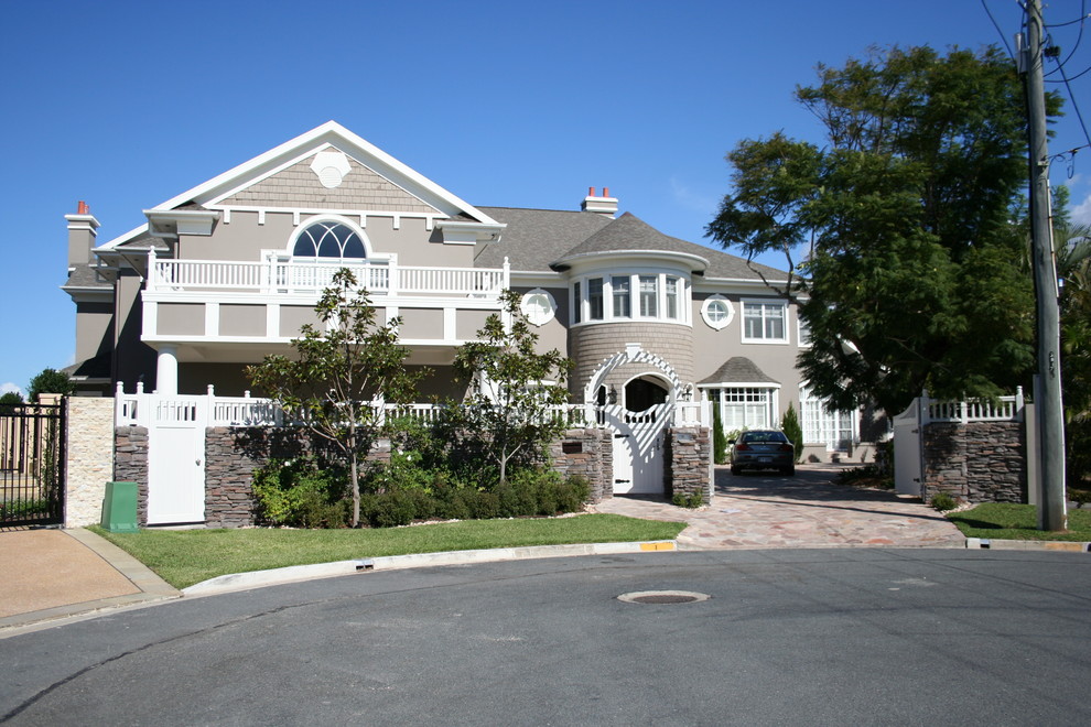 Exemple d'une grande façade de maison grise chic en stuc à un étage avec un toit à deux pans.