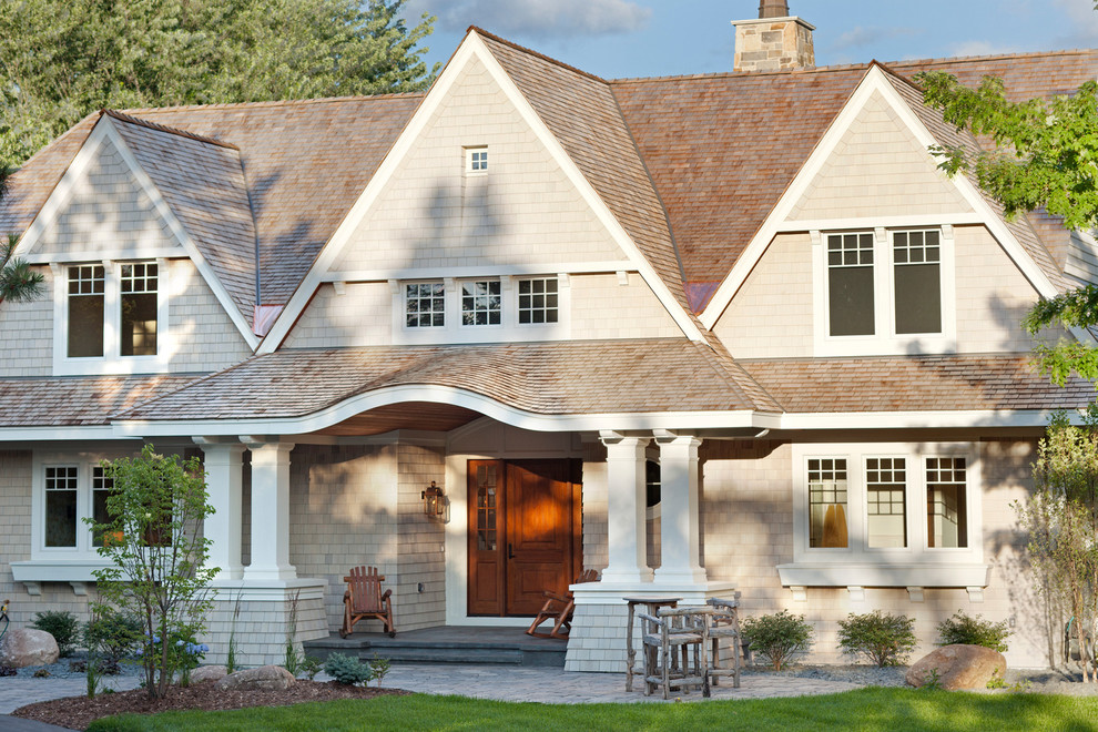 Foto della facciata di una casa beige classica a due piani con tetto a capanna