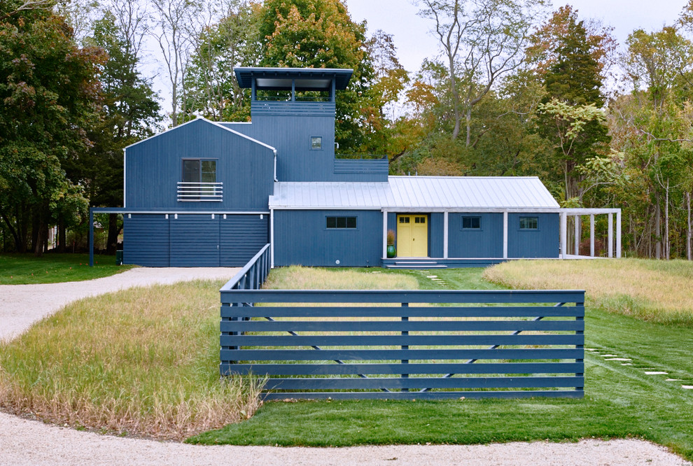 Inspiration pour une façade de maison bleue rustique à un étage avec un toit à deux pans et un toit en métal.
