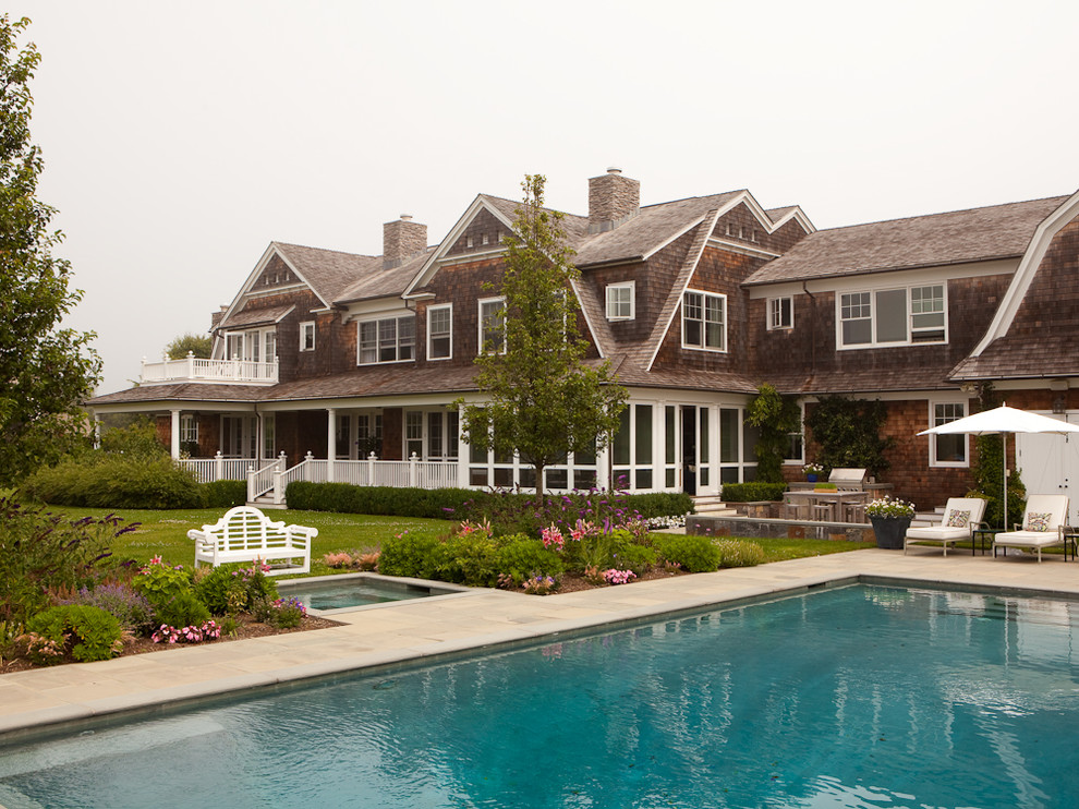Стильный дизайн: огромный, двухэтажный, деревянный, коричневый дом в морском стиле с мансардной крышей - последний тренд