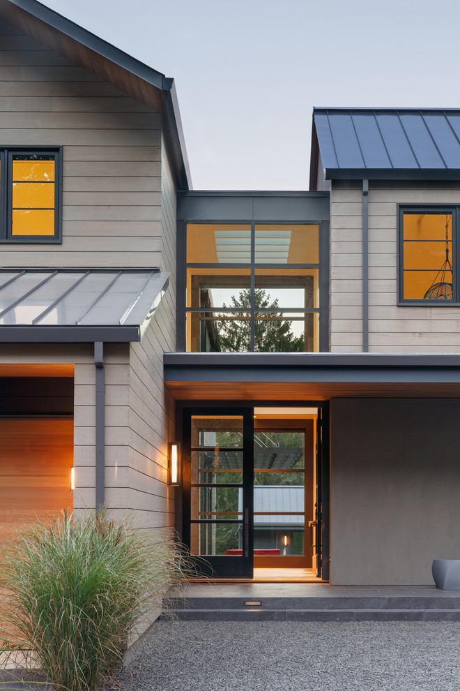 Réalisation d'une façade de maison beige design en bois à un étage avec un toit en appentis.