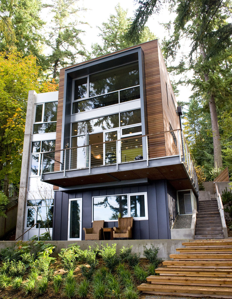 Imagen de fachada de casa marrón actual de tamaño medio de tres plantas con revestimiento de madera y tejado plano