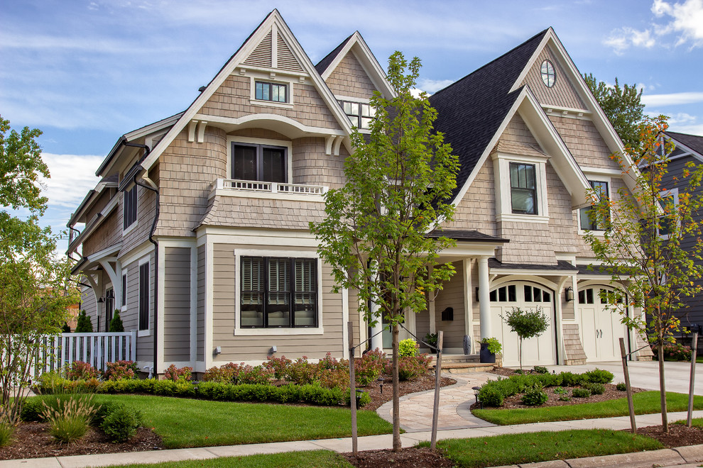 Ejemplo de fachada de casa beige de estilo americano grande de dos plantas con revestimientos combinados, tejado a dos aguas y tejado de teja de madera