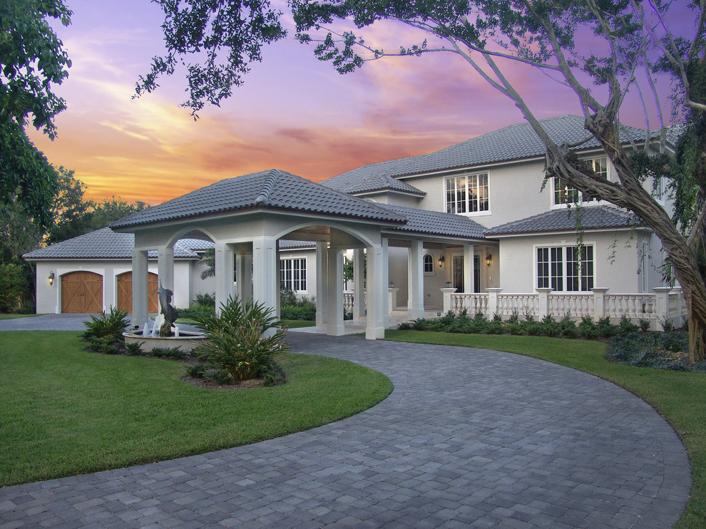 Large elegant gray two-story stone exterior home photo in Miami with a hip roof