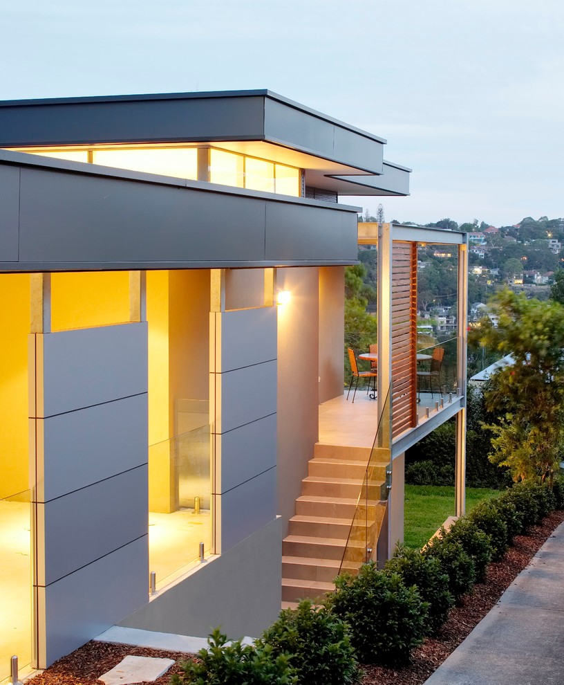 Réalisation d'une façade de maison métallique et beige minimaliste de taille moyenne et à un étage.