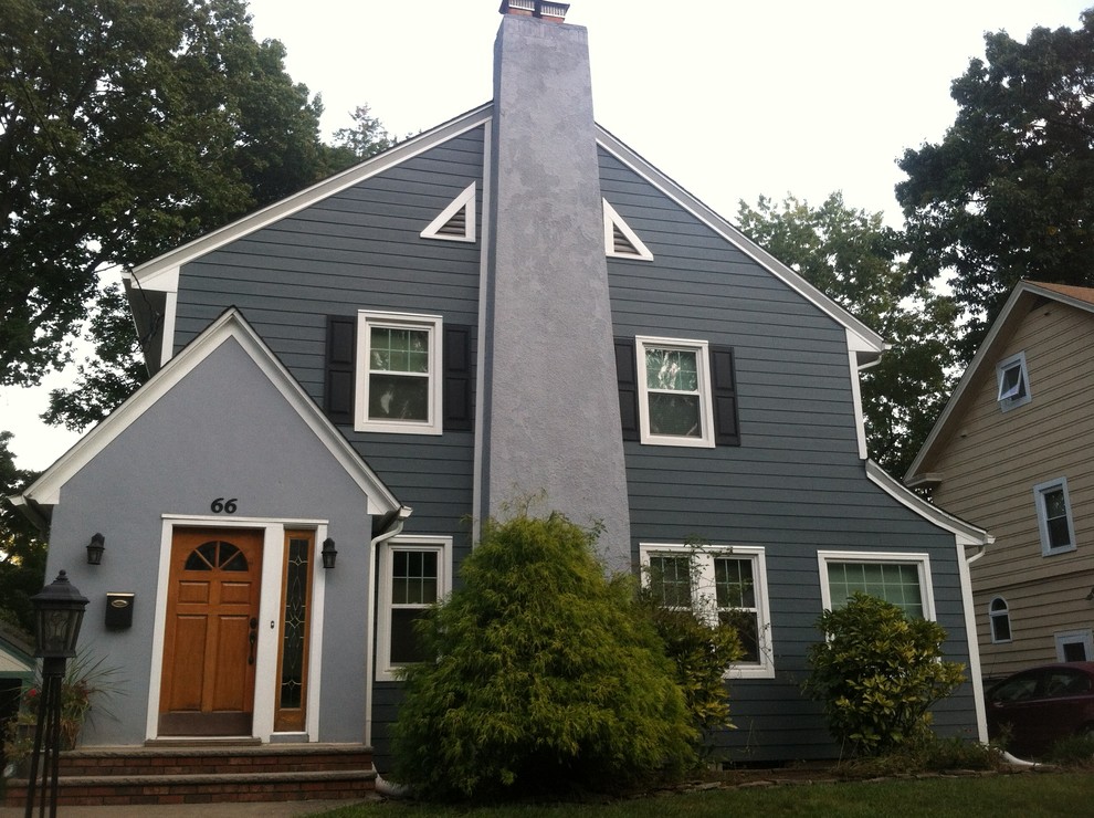 Ejemplo de fachada azul tradicional de tamaño medio de dos plantas con revestimiento de aglomerado de cemento y tejado a dos aguas