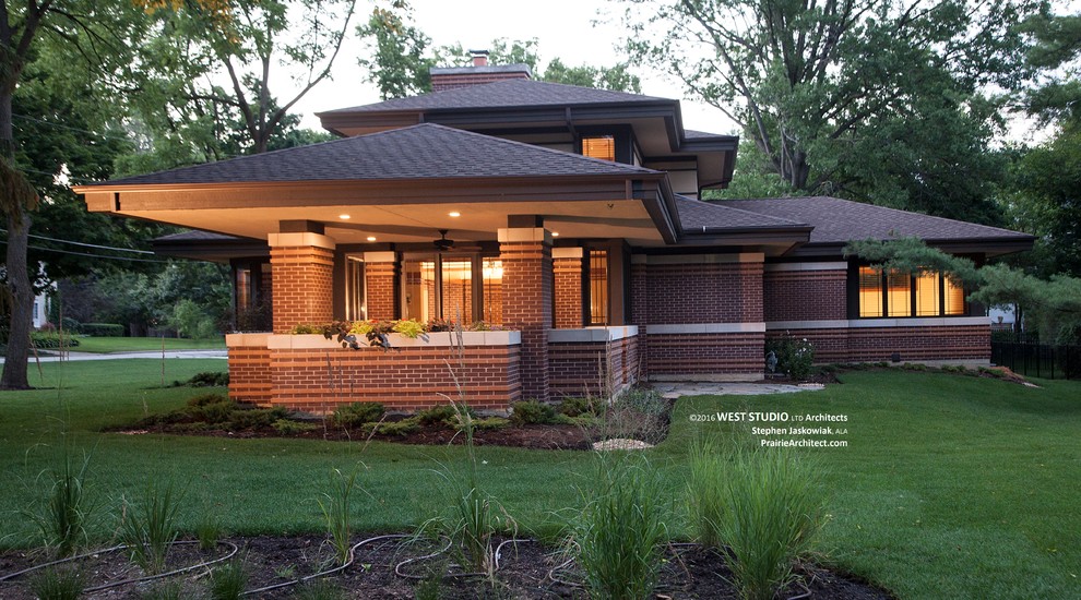 Imagen de fachada de casa multicolor clásica renovada de tamaño medio con revestimiento de ladrillo, tejado a cuatro aguas y tejado de teja de madera