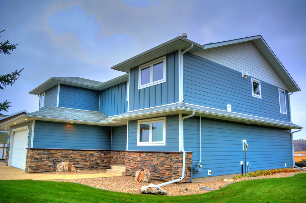 Foto de fachada de casa azul tradicional renovada de tamaño medio de dos plantas con revestimientos combinados y tejado de teja de madera