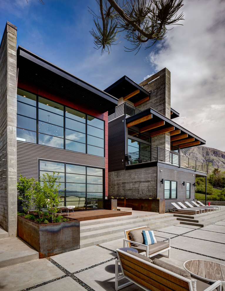 Trendy two-story glass house exterior photo in Salt Lake City