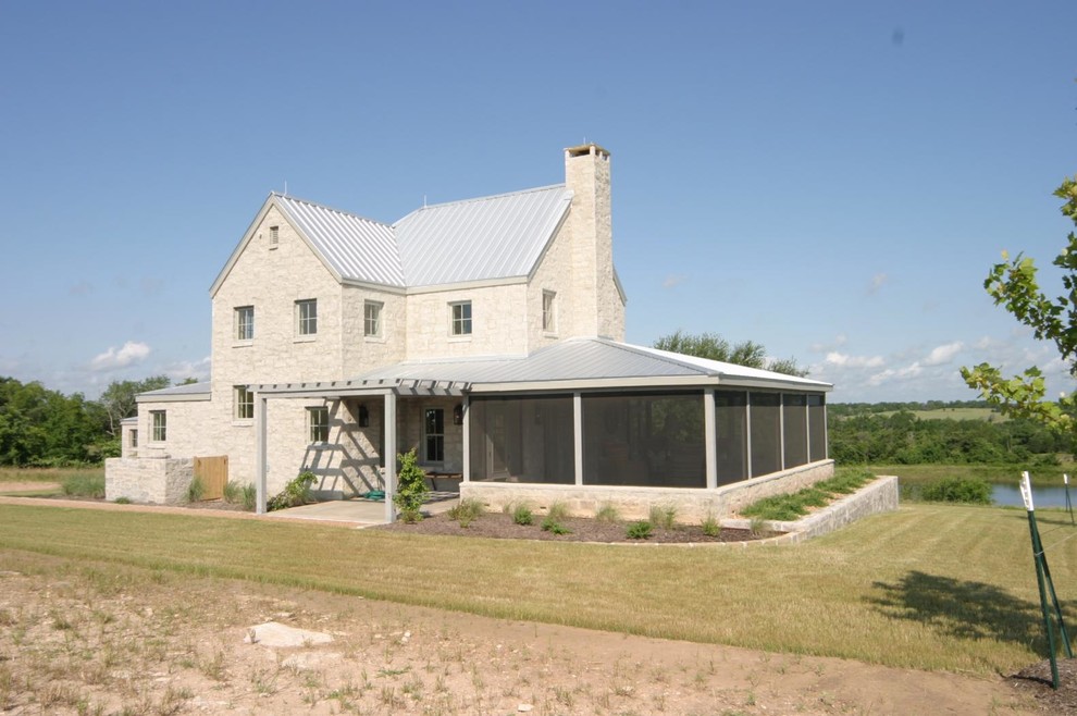 Zweistöckiges, Geräumiges Landhausstil Einfamilienhaus mit Steinfassade, beiger Fassadenfarbe, Satteldach und Blechdach in Austin
