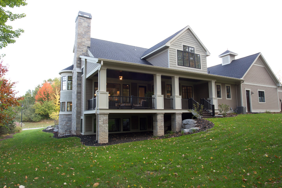 Photo of a medium sized and beige traditional house exterior in Grand Rapids with three floors and a pitched roof.