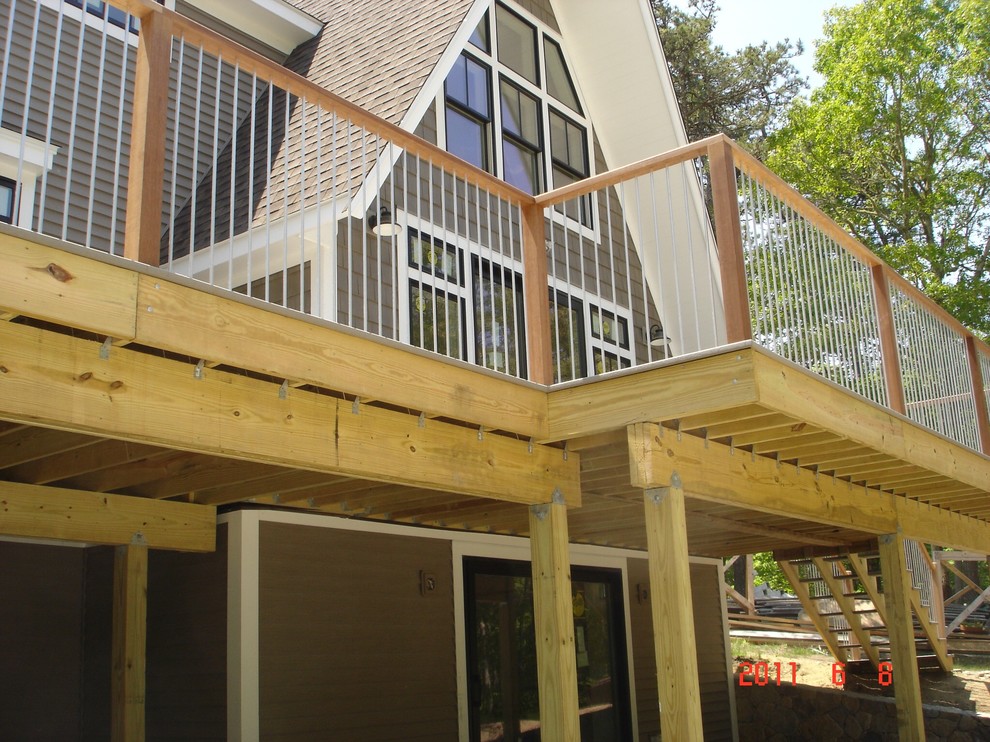 Imagen de fachada de casa marrón clásica de tamaño medio de tres plantas con revestimiento de madera, tejado a dos aguas y tejado de varios materiales